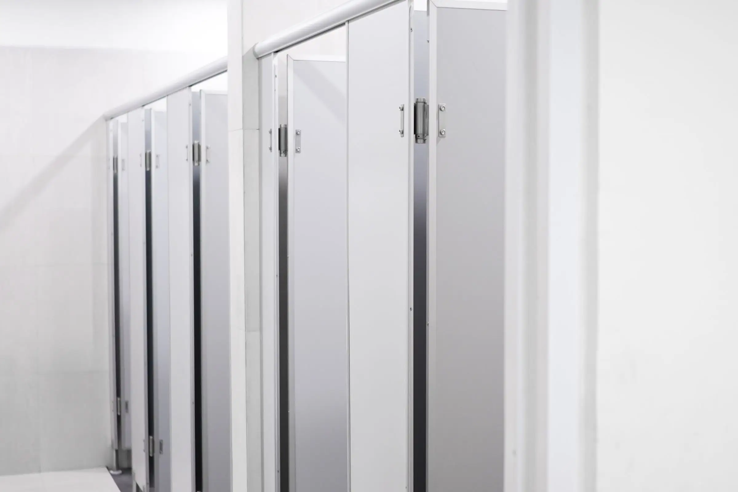 Row of laminate toilet cubicles with stainless steel hardware